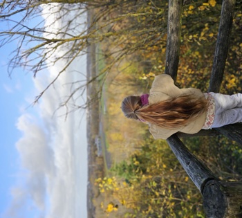 meisje met paardenstaart kijkt op uitzichtpunt uit over de natuur.