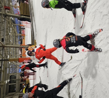 Twee skidocenten met twee kinderen die skiles krijgen in de sneeuw 