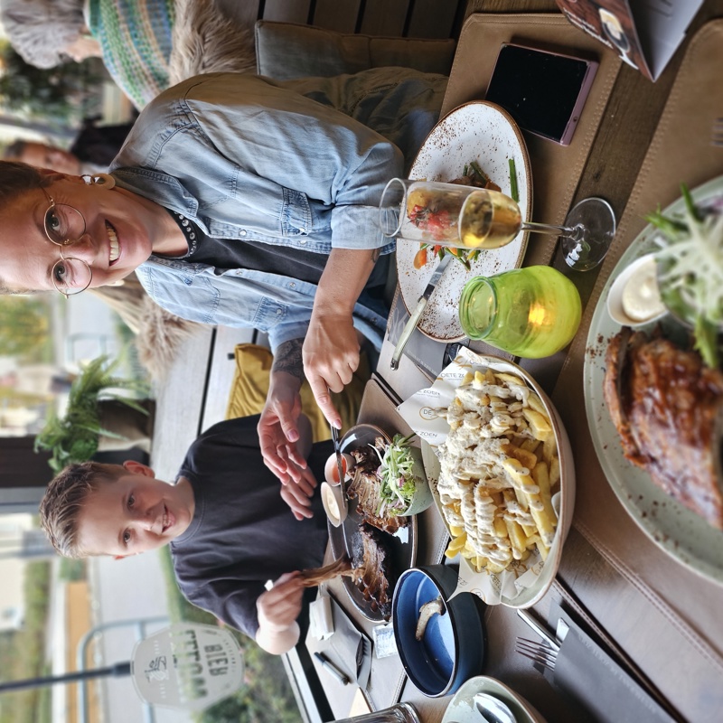 Moeder helpt zoon bij het eten van zijn spareribs bij de Zoete Zoen in Valkenburg