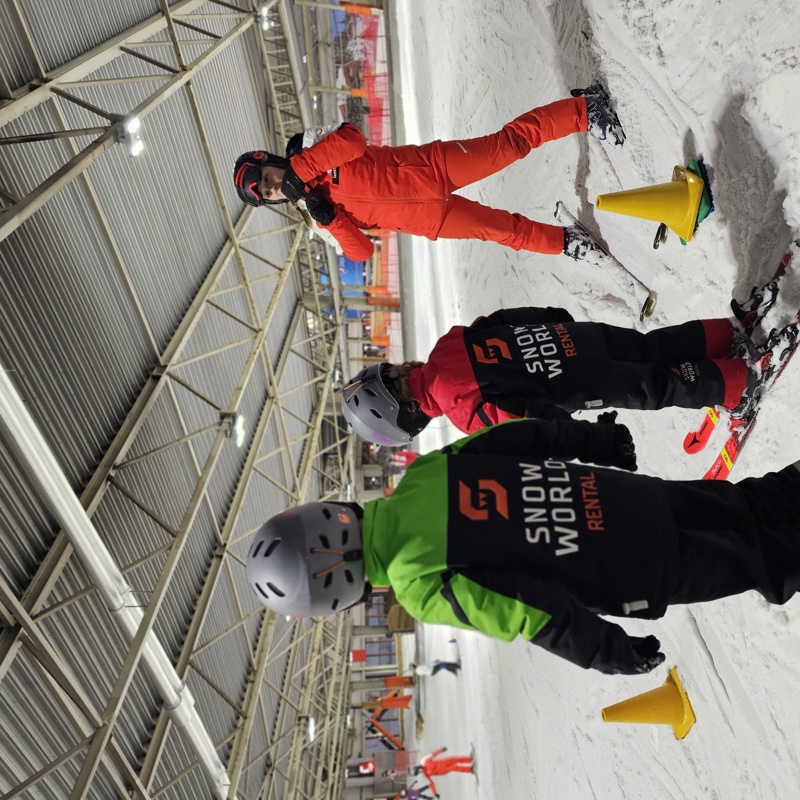 Twee kinderen op ski's luisteren naar skidocent 