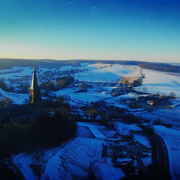 Luchtfoto van winters landschap met kerktoren