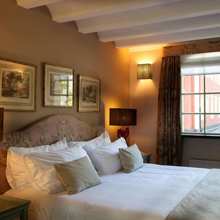 klassieke hotelkamer met opgemaakt bed. 