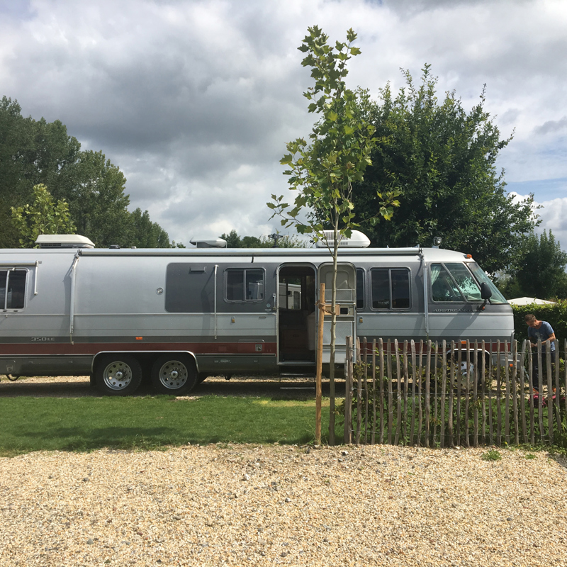 Lange omgebouwde camper op een camperplaats. 