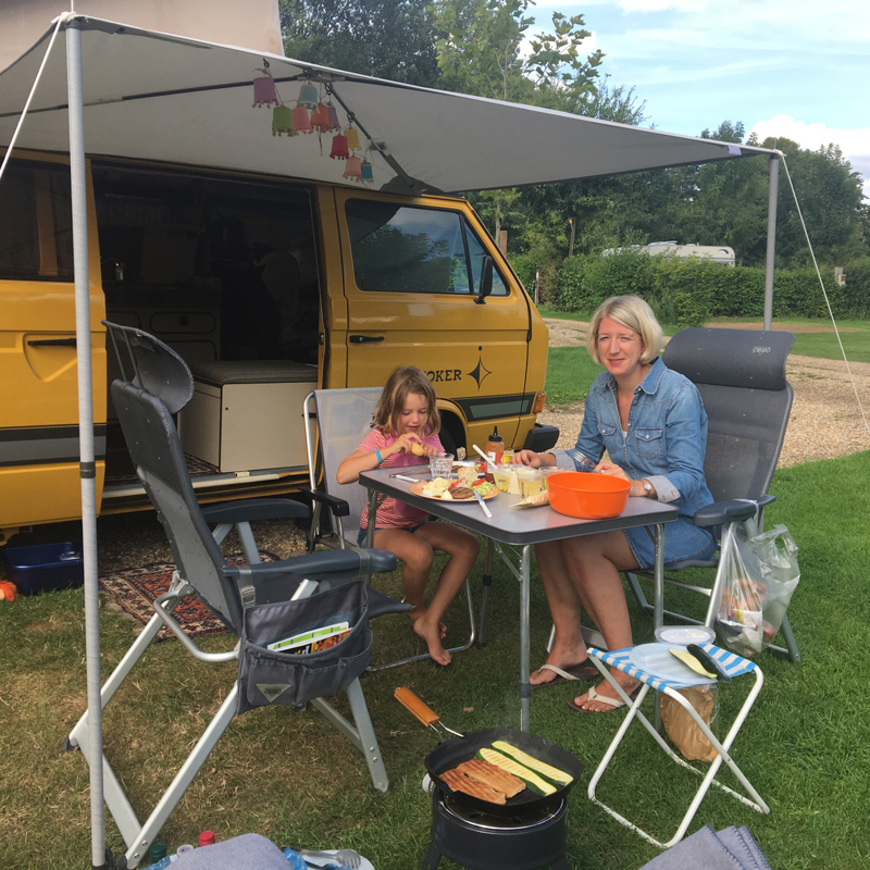 Moeder en dochter genieten van een barbecue op de camping. 