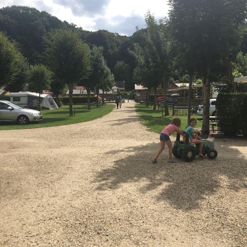 Kinderen spelen op een speelgoed tractor op de camping. 