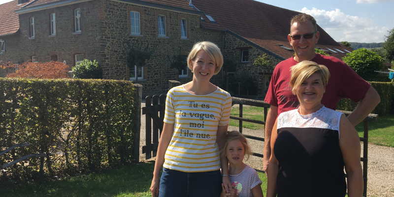 Vrouw en dochter poseren met eigenaren voor de vakantiehoeve. 