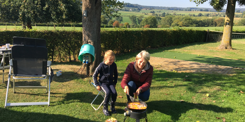 Moeder is aan het koken op gaspitje op de camping. 