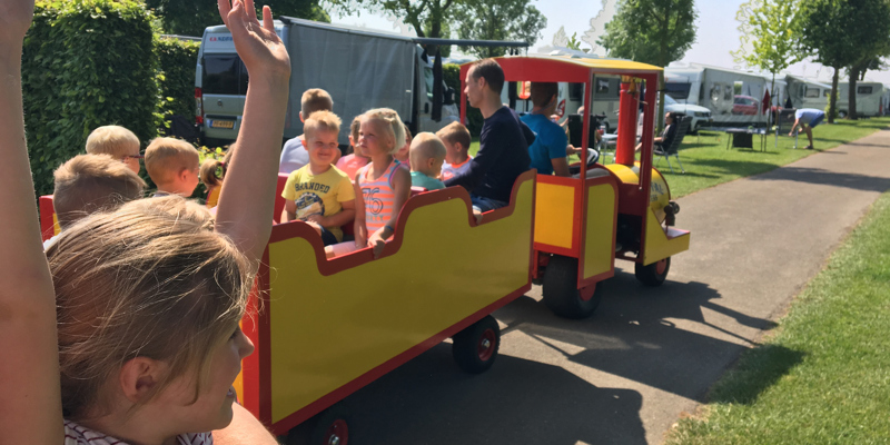 Kinderen in een treintje op de camping.