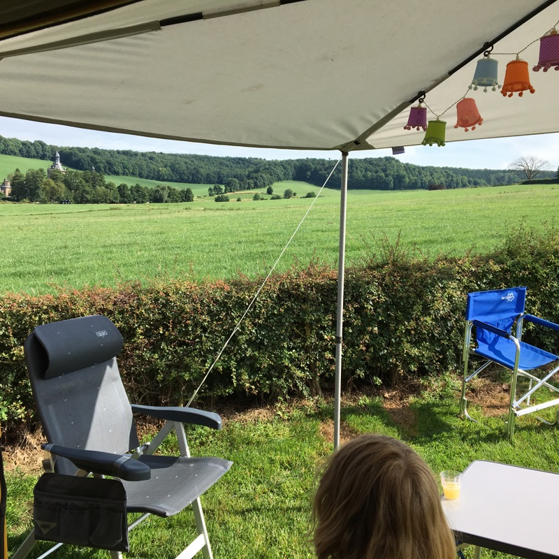 Aangrenzende voortent aan het gele camperbusje met versiering. 