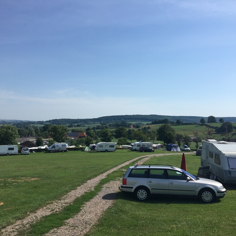 Sfeerfoto van een campingplaats met diverse caravans in de verte. 