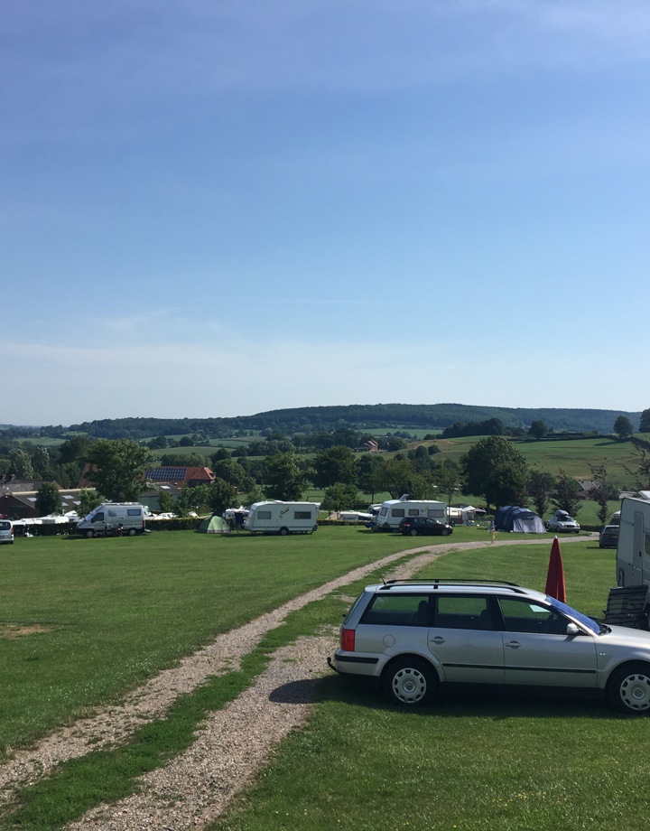 Sfeerfoto van een campingplaats met diverse caravans in de verte. 