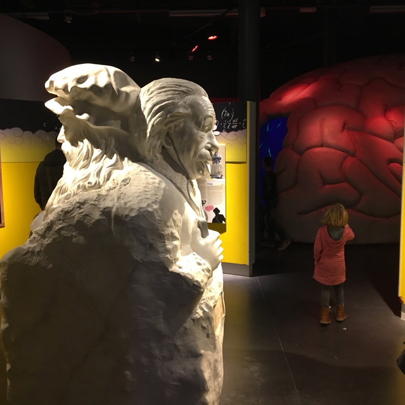 Meisje in museum met beeld van onder andere Einstein