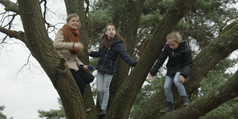 Presentatrice in een grote boom met 2 meisjes