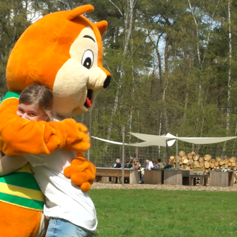 Jonge vrouw knuffelt Eekhoorn mascotte