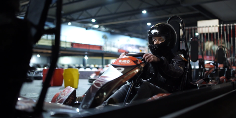 Jonge vrouw met zwarte helm in kart