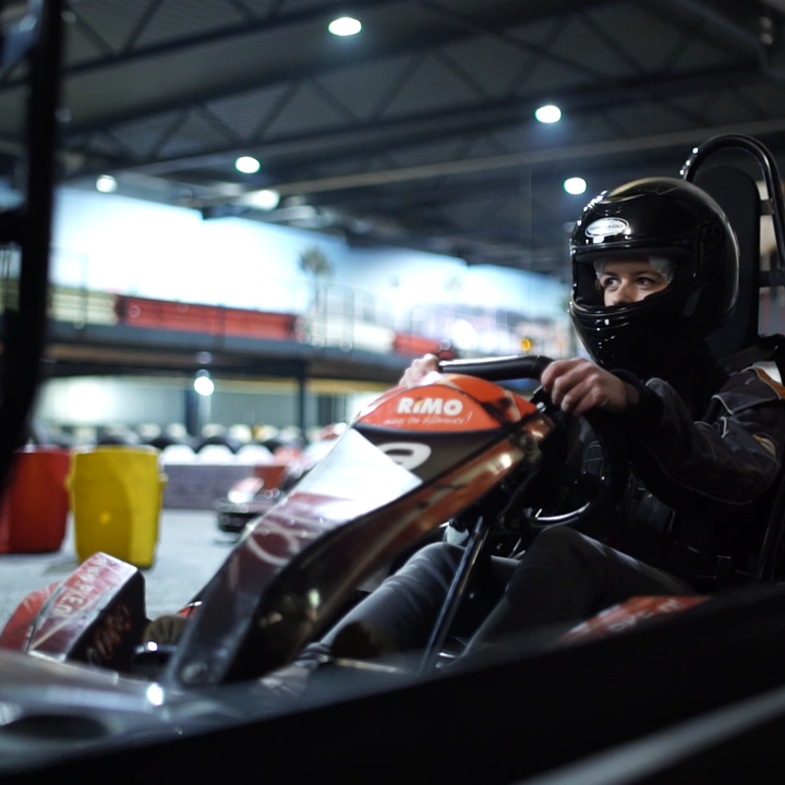 Jonge vrouw met zwarte helm in kart