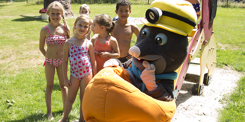 Kinderen poseren in badkleding naast mascotte Hoopie de Mol