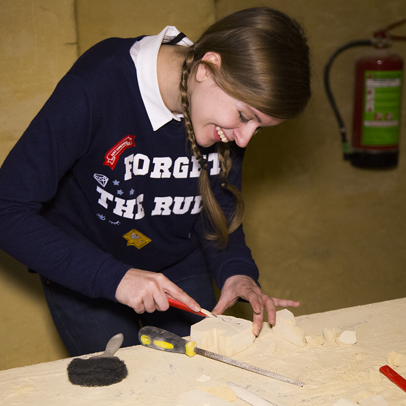 Jonge vrouw maakt kunstwerkje van mergel