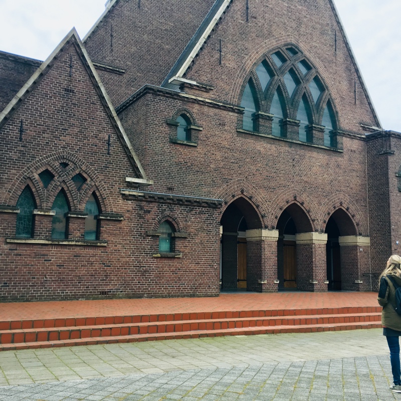 Persoon staat voor de Sint-Franciscus van Assisiëkerk Heerlen