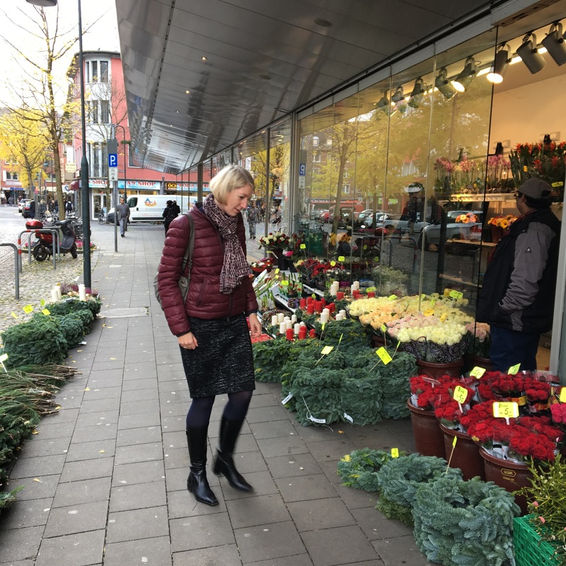 vrouw bekijkt bloemen bij bloemenkraam