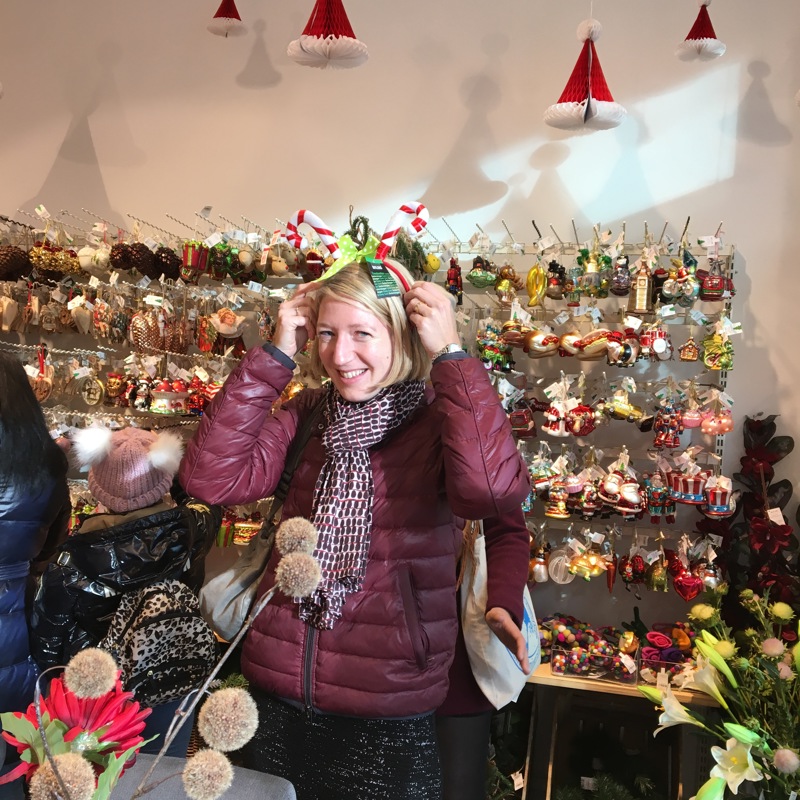 vrouw past kerstdiadeem in kerstwinkeltje