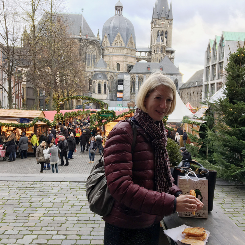 Vrouw eet reibekuchen op kerstmarkt