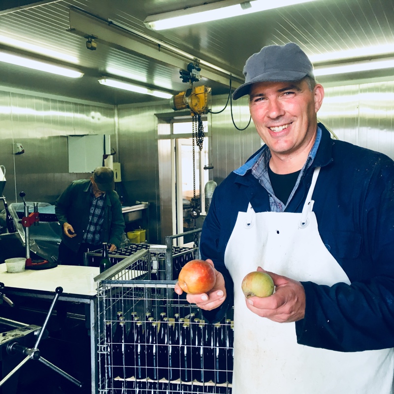 Een fruitboer houdt twee appels vast in zijn machinekamer
