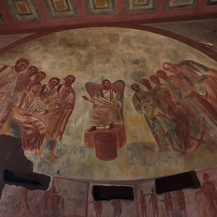 Detail op beschilderde koepel in de Romeinse Katakomben. Een raadsman met andere mannen eromheen.