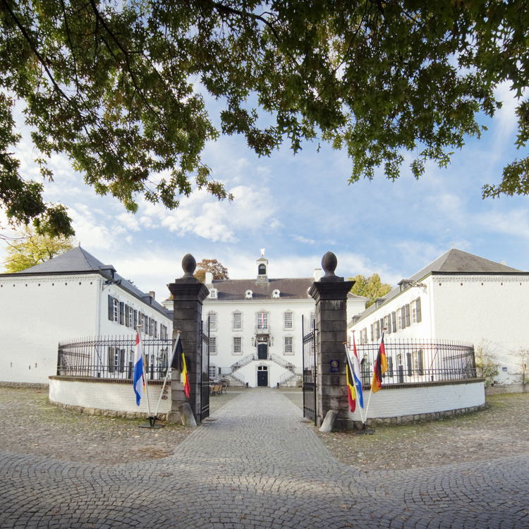 Aanzicht van Kasteel Vaalsbroek met vlaggen bij ingang van de poort