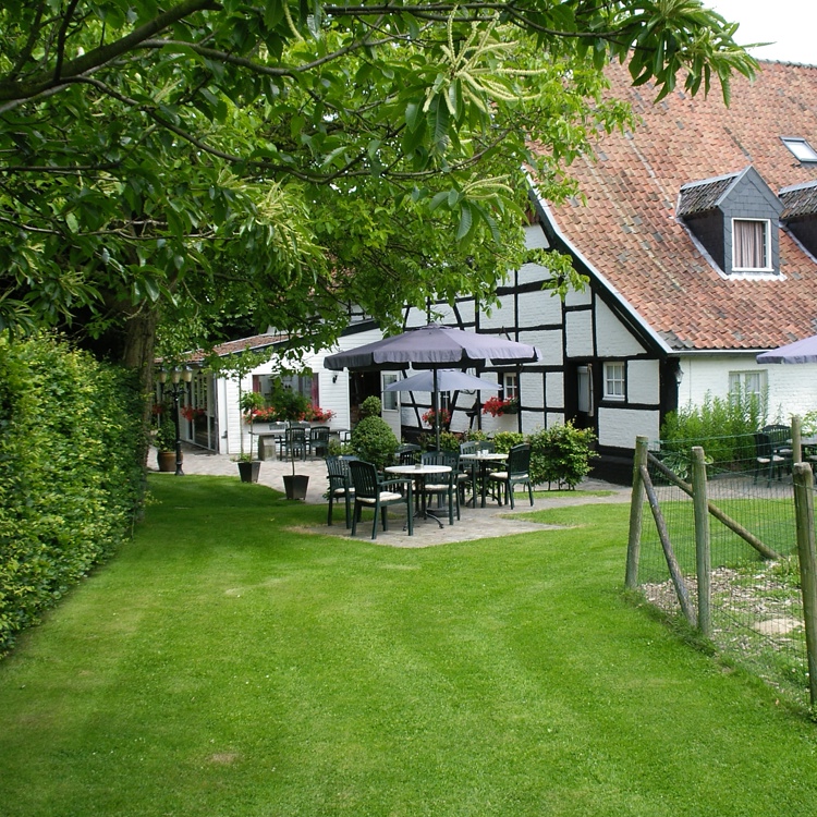 Vakwerkwoning met klein terras en een prachtige tuin ervoor. 