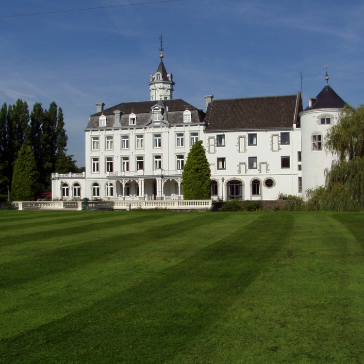 chique wit statig hotel met een strak grasveld ervoor. 