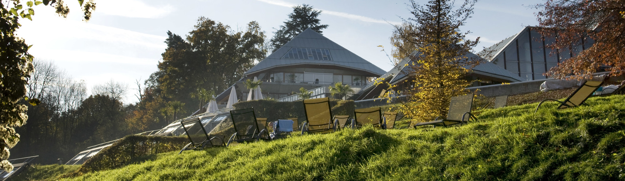 Piramide van wellnessresort thermae en ligbedjes op een ligweide. 