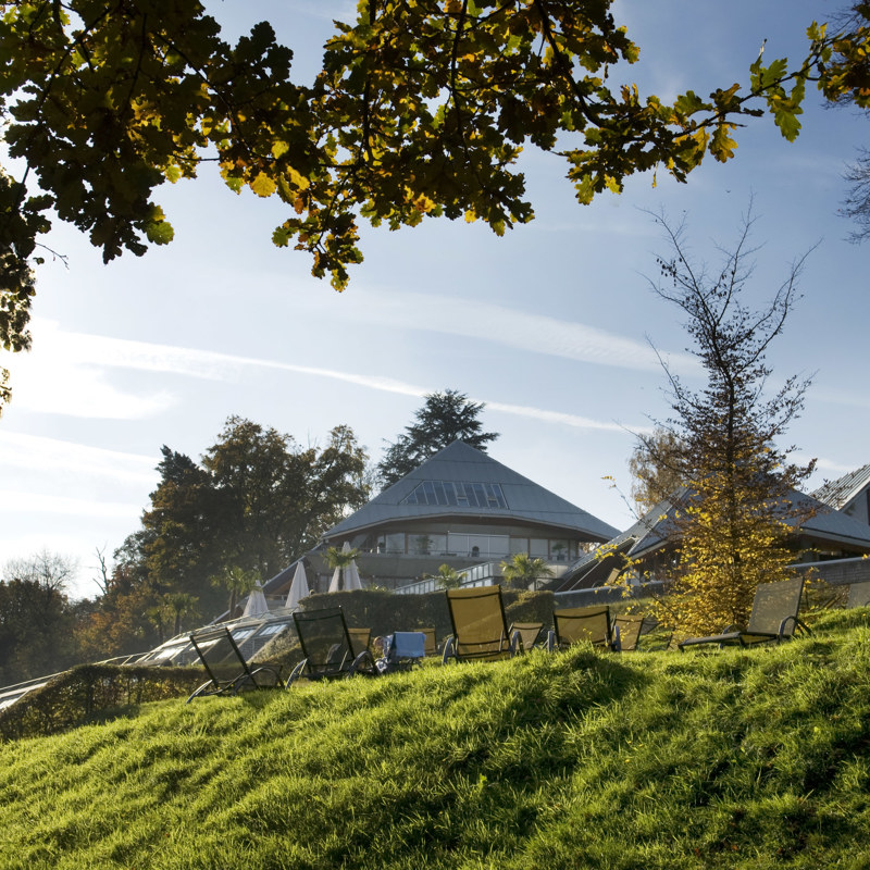 Piramide van wellnessresort thermae en ligbedjes op een ligweide. 