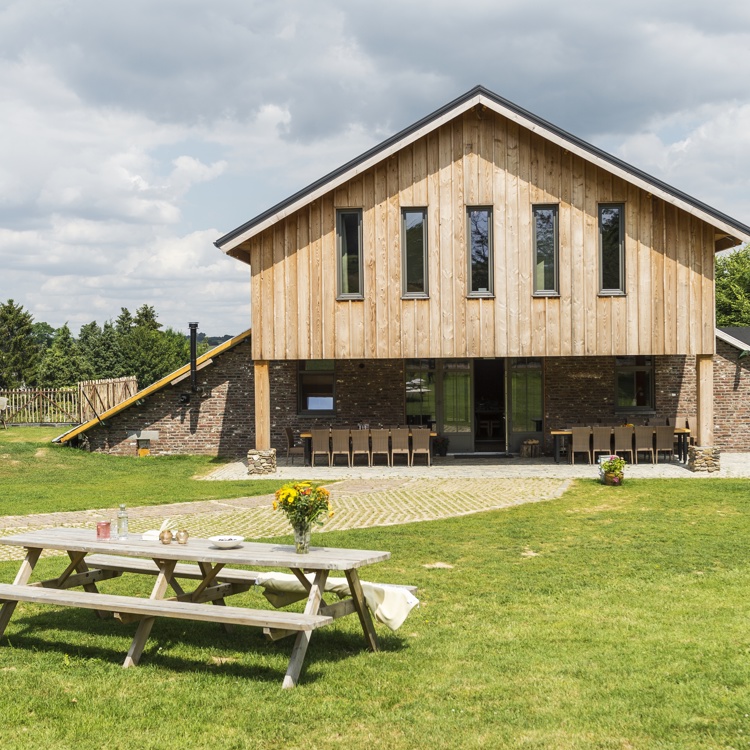 Groep accommodatie met grasveld en picknickbank. 