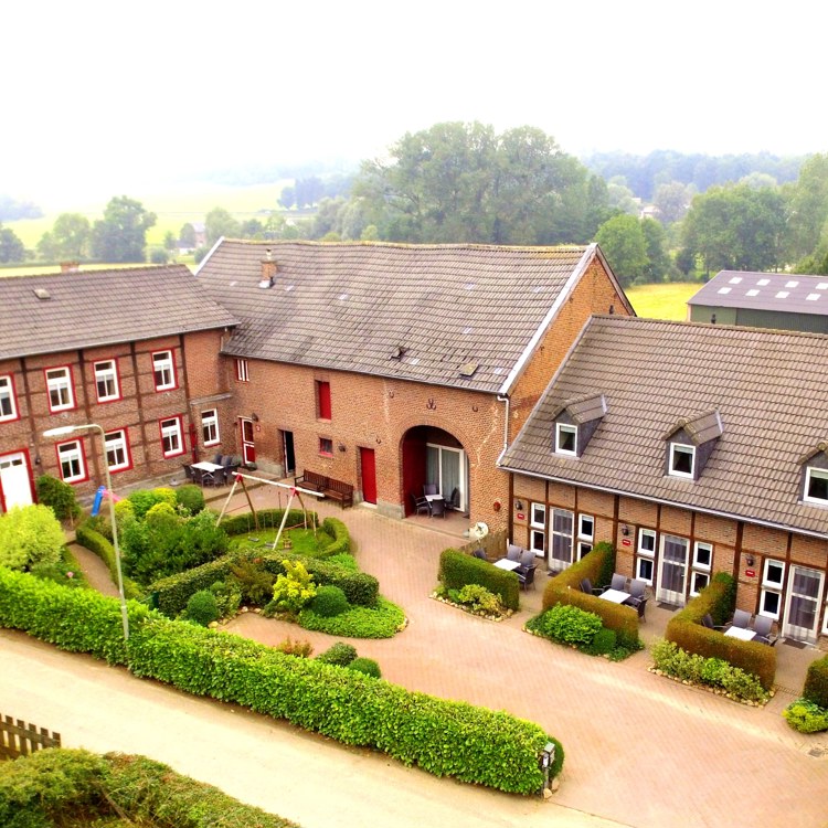 Bovenaanzicht van een grote boerderij met een binnenplaats. 