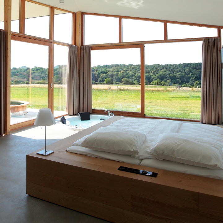 Luxe loft met tweepersoonsbed en een rond bubbelbad in de kamer