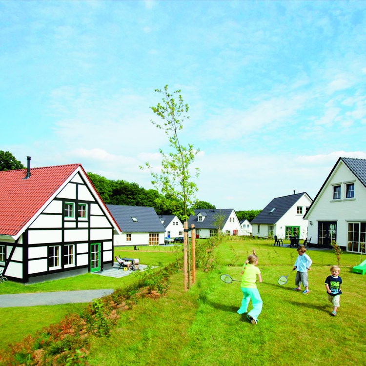 spelende kinderen in de tuin van een vakantiehuisje in een vakantiepark. 