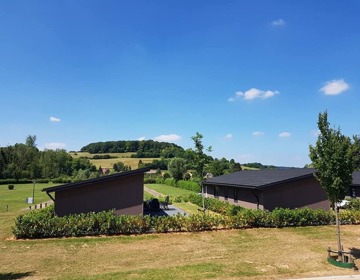 Uitzicht vanaf het vakantiepark over de heuvels met bomen.