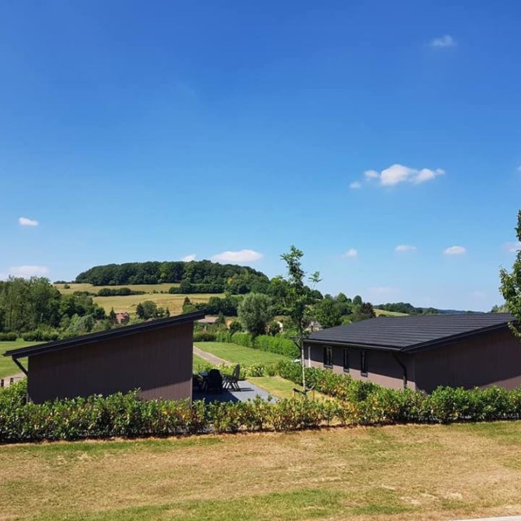 Uitzicht vanaf het vakantiepark over de heuvels met bomen.