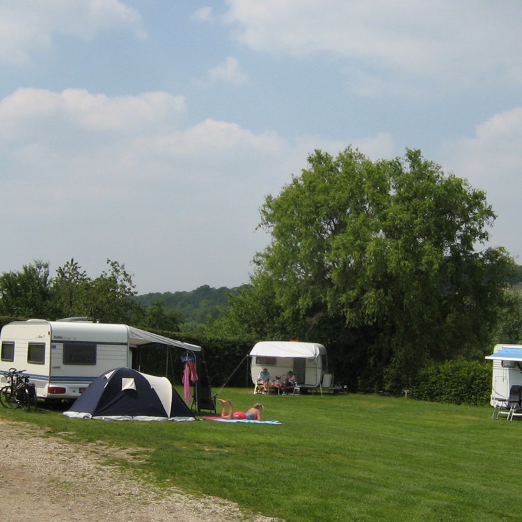 Weide met enkele caravans en tentjes. 