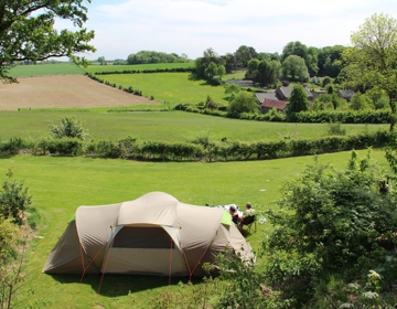 Grote tent in een weids landschap met vrij uitzicht. 