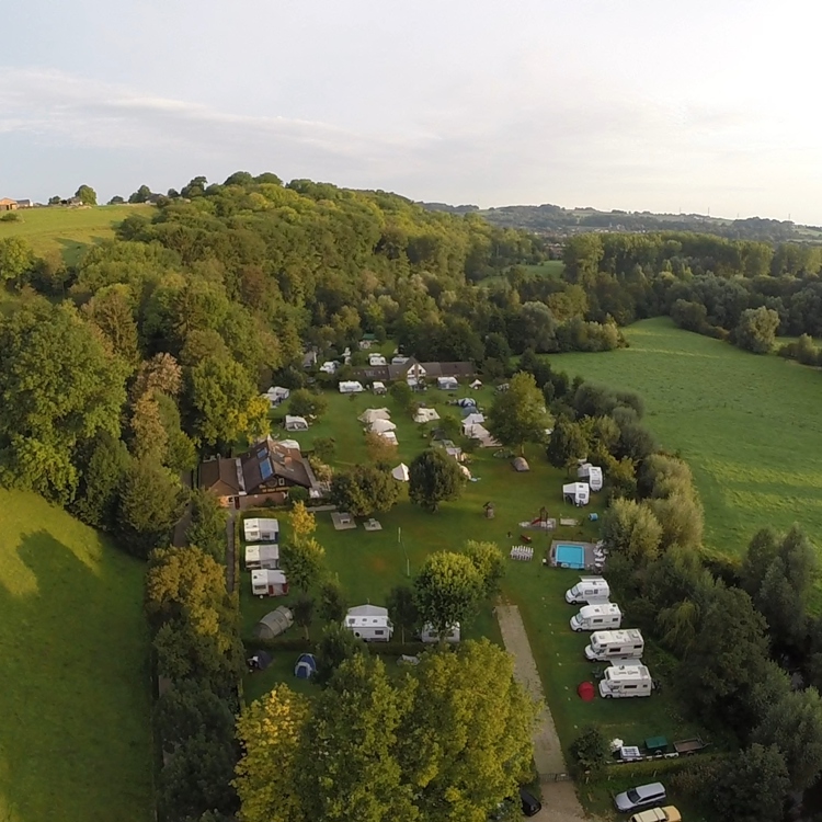 Luchtfoto van een camping in een natuurrijke omgeving. 