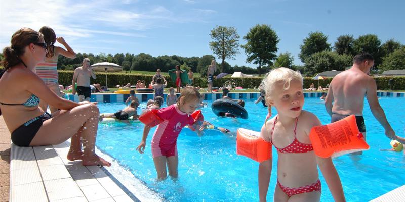 Drukbezocht buitenbad in de zomer met kinderen. 