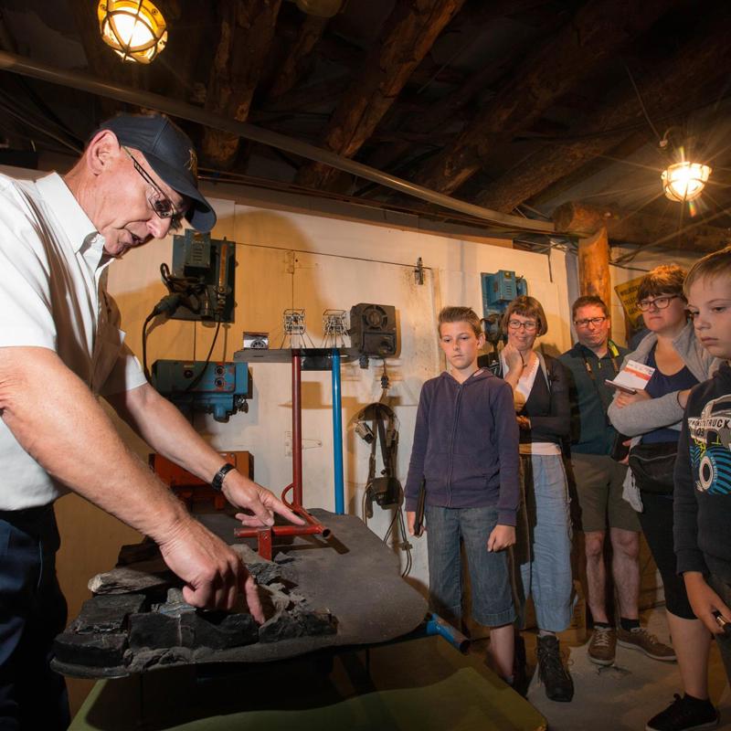 Gids geeft rondleiding aan groep mensen in het Mijnmuseum Beringen België