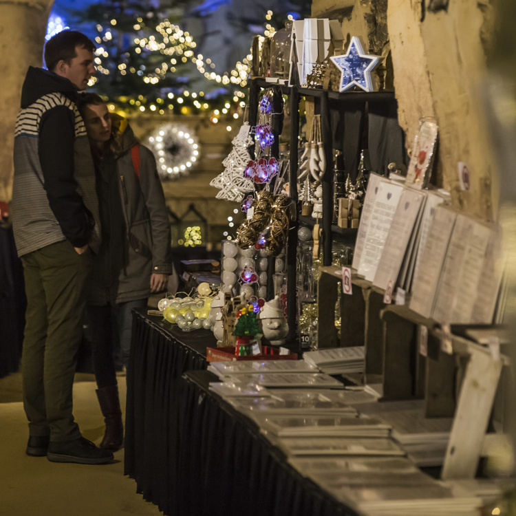 Kerstmarkt Fluweelengrot Verliefd Koppel kijkend naar kerstspulletjes in stand