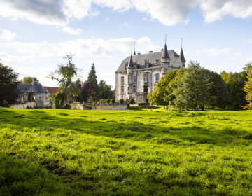 Aanzicht van Kasteel Schaloen met grasveld op de voorgrond