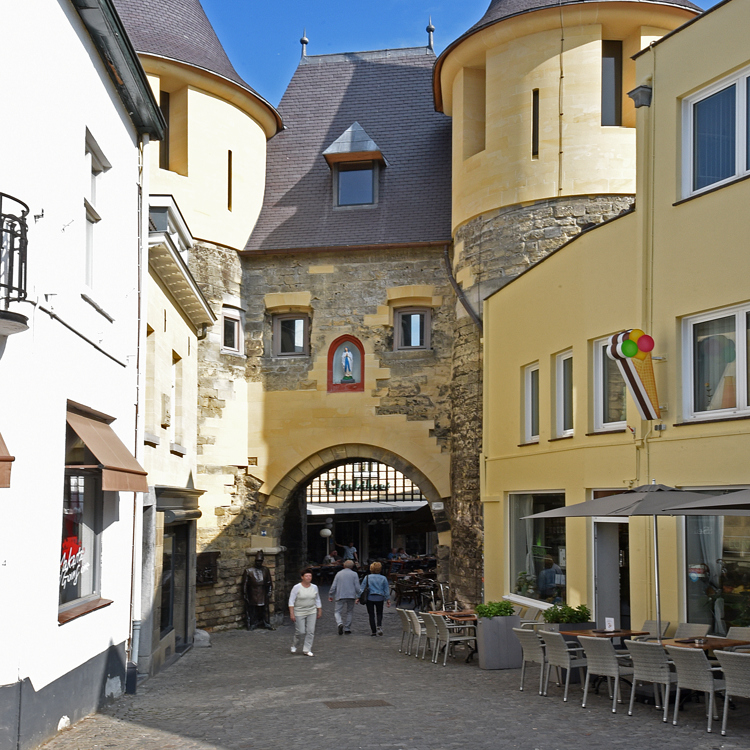 Mensen lopen richting Grendelpoort in Valkenburg