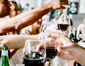 Een gezelschap aan tafel proost met wijn