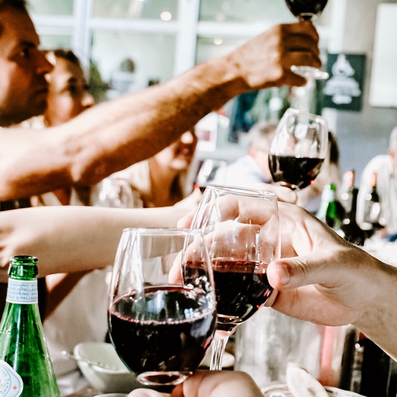 Een gezelschap aan tafel proost met wijn