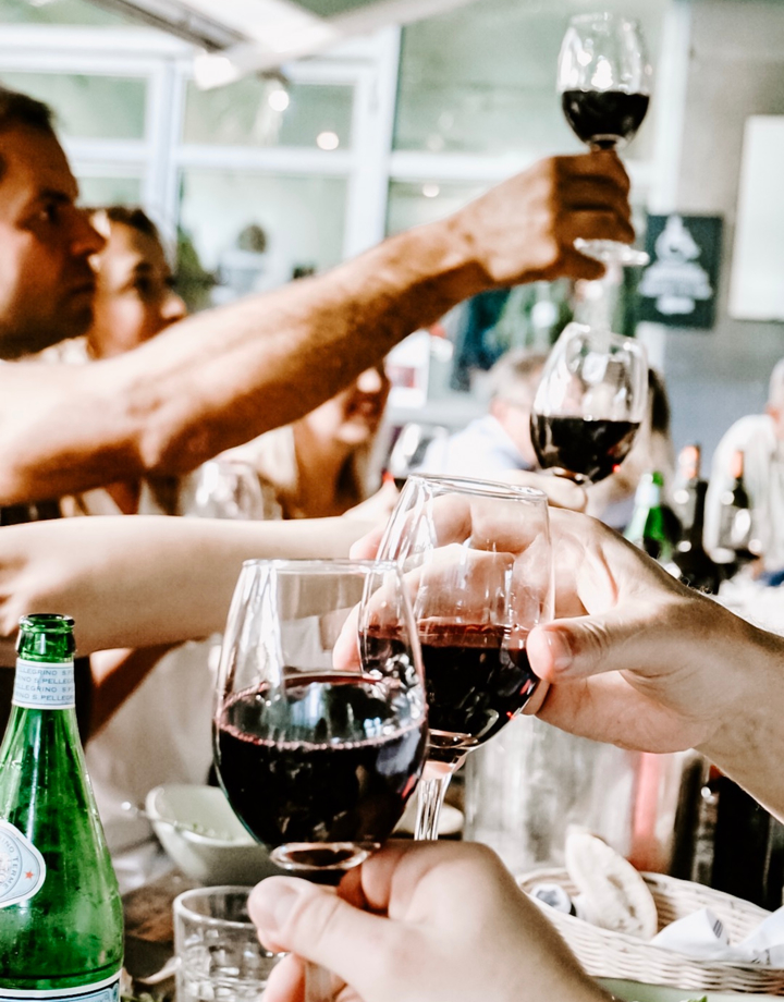 Een gezelschap aan tafel proost met wijn